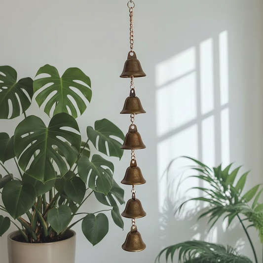 Carillon feng shui 6 clochettes dorées en situation avec plantes vertes - ambiance zen intemporelle